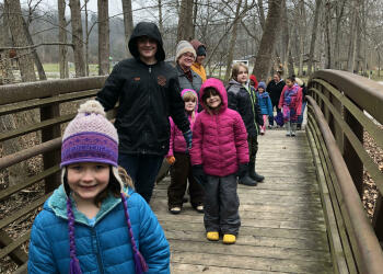 Kids hiking on a bridge.