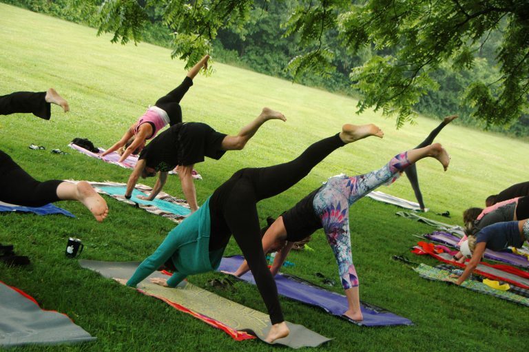 people doing yoga in park