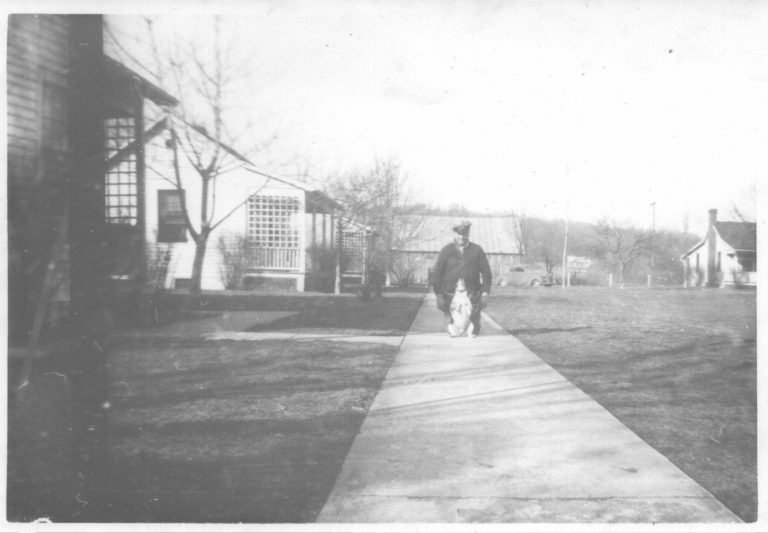 black and white photo of lady walking down street