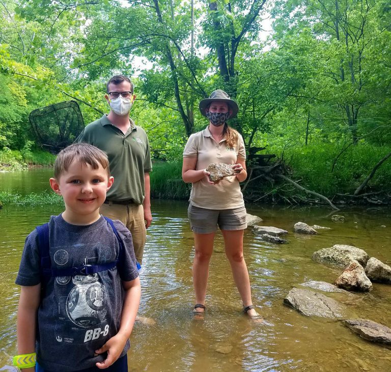 three people standing in river